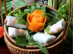 Nem Cuốn tôm : Fresh spring rolls with Prawns; An iconic appetizer in the refined culinary culture of Hanoi, these fresh spring rolls are a quintessential starter for festive family gatherings and cheerful reunions among friends. Beautifully handcrafted, the dish highlights fresh, succulent boiled shrimp, peeled and rolled alongside soft rice vermicelli, crisp cucumber, sweet pineapple, bright carrots, and a vibrant bouquet of fresh local herbs. The dish truly comes alive with its delicate dipping sauce—a finely balanced blend of fragrant fish sauce, minced garlic, and fresh chili, softened by the subtle sweetness of banana vinegar, a squeeze of fresh lime, and a gentle touch of sugar for a crisp, refreshing finish. • Key Ingredients: Fresh boiled shrimp, rice vermicelli, pineapple, cucumber, carrot, fresh herbs, rice paper. • Flavor Profile: Fresh and crisp with natural sweetness from seafood and fruit, balanced by an aromatic, sweet-and-sour garlic-chili dipping sauce.